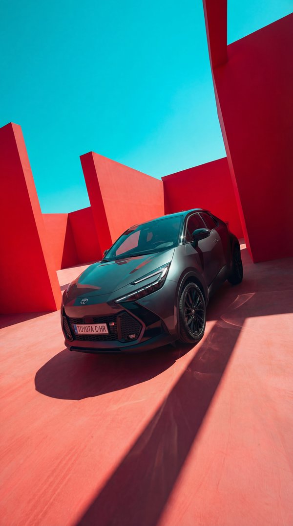 Toyota C-HR in bold red geometric architectural setting with cyan sky