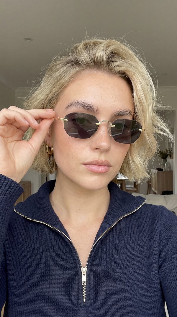 AI photoshoot: blonde woman adjusting rimless gold sunglasses casual portrait